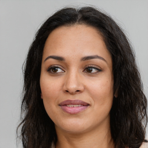 Joyful latino adult female with long  brown hair and brown eyes