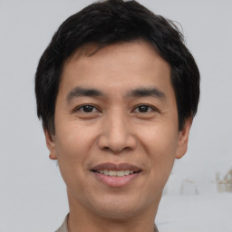 Joyful asian young-adult male with short  black hair and brown eyes