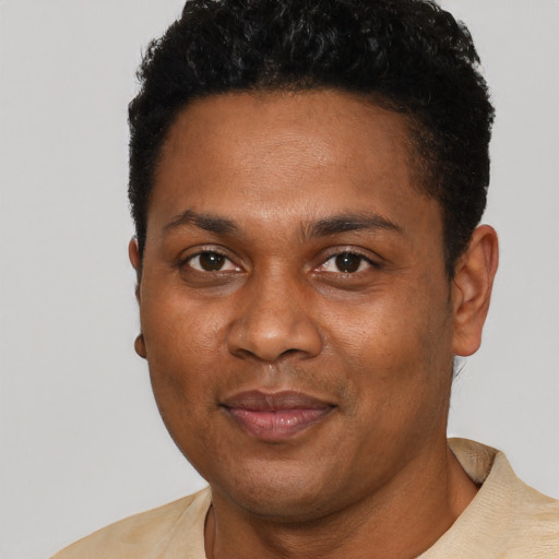 Joyful black young-adult male with short  black hair and brown eyes