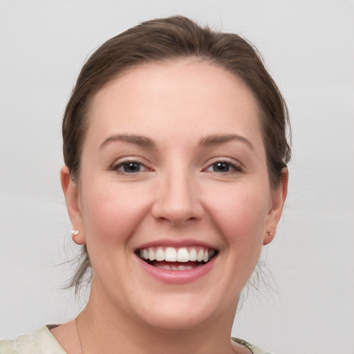 Joyful white young-adult female with medium  brown hair and grey eyes