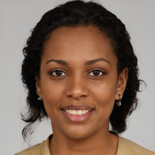 Joyful black young-adult female with medium  brown hair and brown eyes