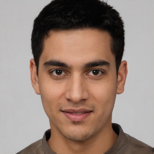 Joyful latino young-adult male with short  black hair and brown eyes