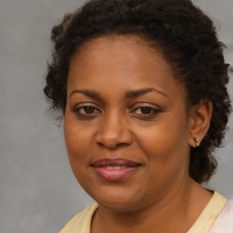 Joyful black adult female with medium  brown hair and brown eyes