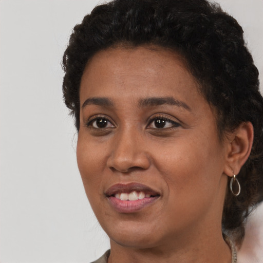 Joyful black young-adult female with short  brown hair and brown eyes