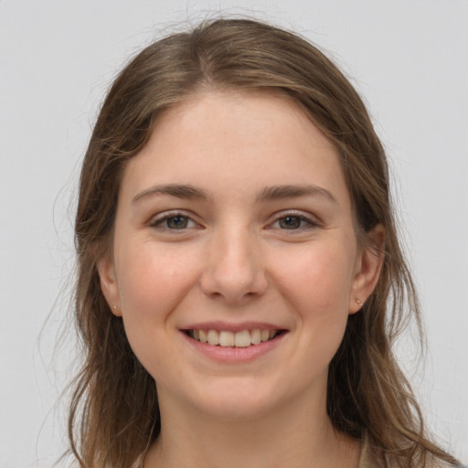 Joyful white young-adult female with long  brown hair and grey eyes