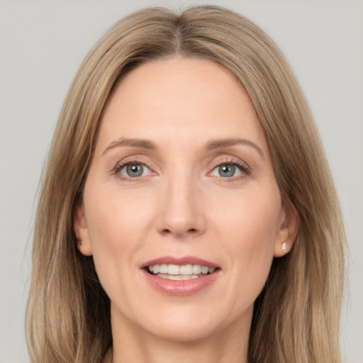 Joyful white adult female with long  brown hair and grey eyes