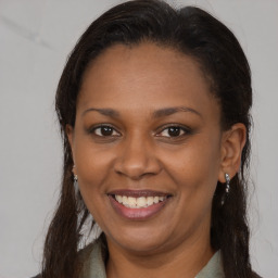 Joyful black young-adult female with long  brown hair and brown eyes