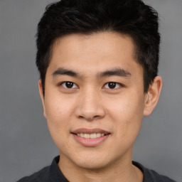 Joyful asian young-adult male with short  brown hair and brown eyes