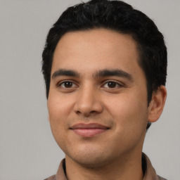 Joyful latino young-adult male with short  black hair and brown eyes