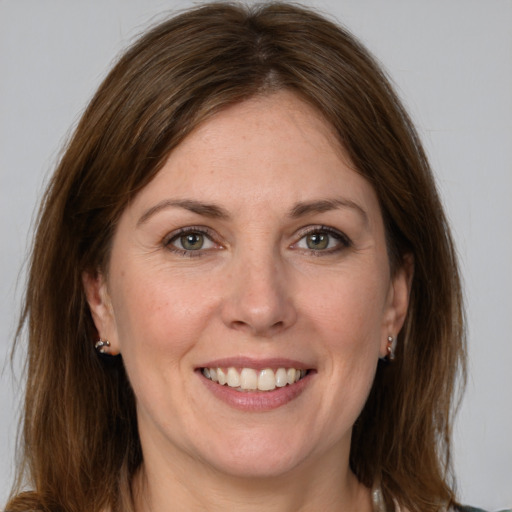 Joyful white young-adult female with medium  brown hair and grey eyes