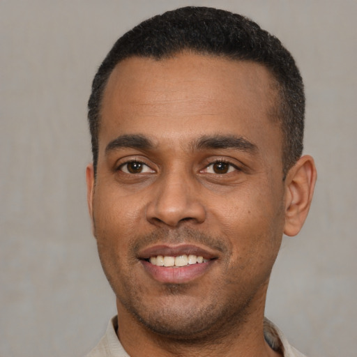 Joyful latino young-adult male with short  black hair and brown eyes