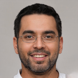 Joyful white young-adult male with short  black hair and brown eyes