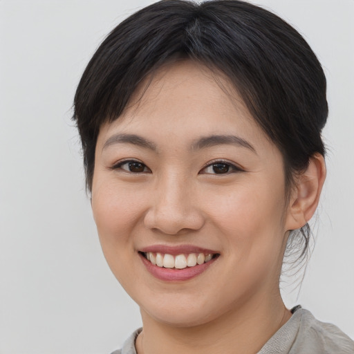 Joyful asian young-adult female with medium  brown hair and brown eyes