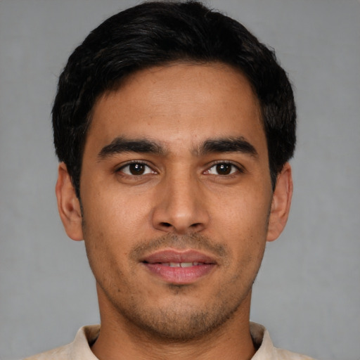 Joyful latino young-adult male with short  black hair and brown eyes