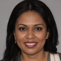 Joyful black young-adult female with long  brown hair and brown eyes