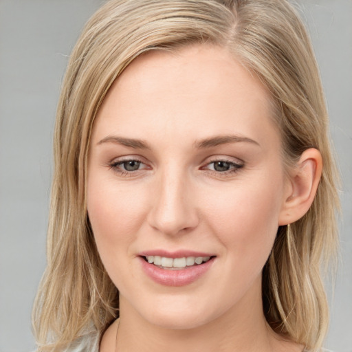 Joyful white young-adult female with long  brown hair and blue eyes