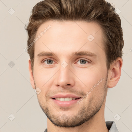 Joyful white young-adult male with short  brown hair and grey eyes