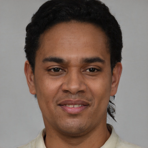 Joyful latino young-adult male with short  black hair and brown eyes