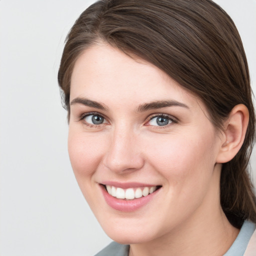 Joyful white young-adult female with medium  brown hair and grey eyes