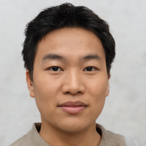Joyful asian young-adult male with short  black hair and brown eyes
