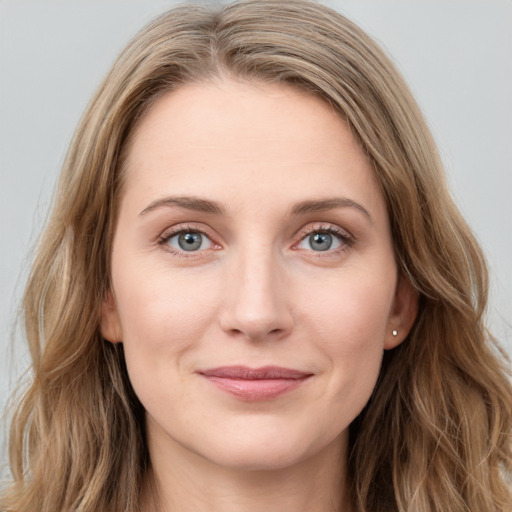 Joyful white young-adult female with long  brown hair and blue eyes