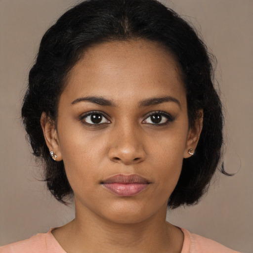 Joyful black young-adult female with medium  brown hair and brown eyes