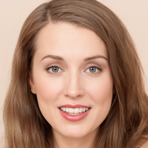 Joyful white young-adult female with long  brown hair and blue eyes