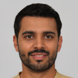 Joyful latino young-adult male with short  black hair and brown eyes