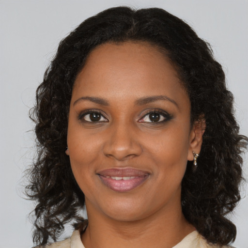 Joyful black young-adult female with medium  brown hair and brown eyes
