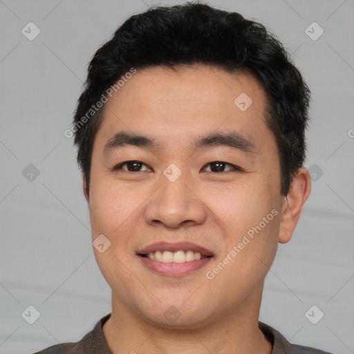 Joyful asian young-adult male with short  black hair and brown eyes