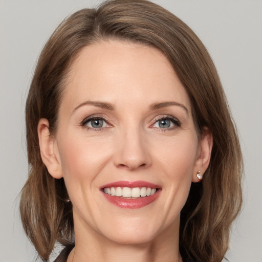 Joyful white adult female with medium  brown hair and grey eyes