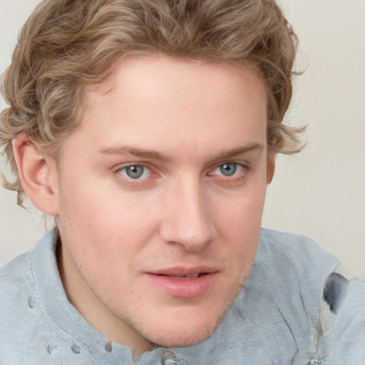 Joyful white young-adult male with short  brown hair and blue eyes