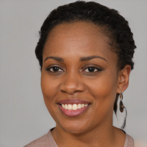Joyful black young-adult female with short  brown hair and brown eyes