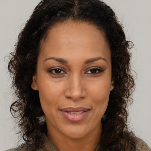 Joyful latino adult female with long  brown hair and brown eyes