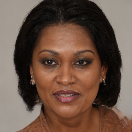 Joyful black adult female with medium  brown hair and brown eyes