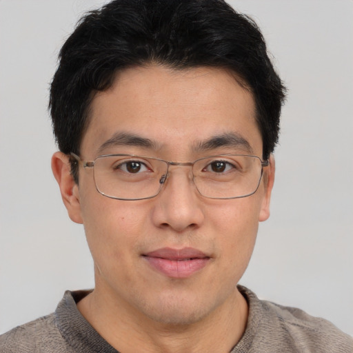 Joyful asian young-adult male with short  brown hair and brown eyes