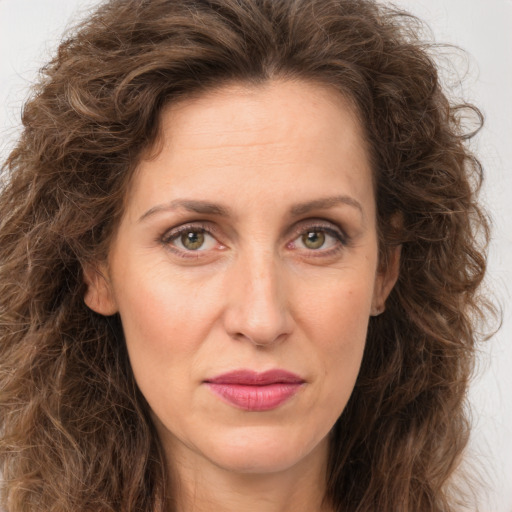 Joyful white adult female with long  brown hair and green eyes