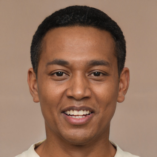 Joyful black young-adult male with short  black hair and brown eyes