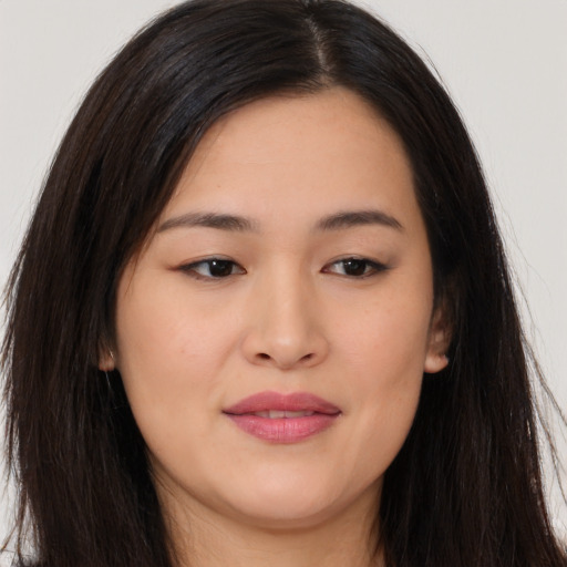 Joyful asian young-adult female with long  brown hair and brown eyes