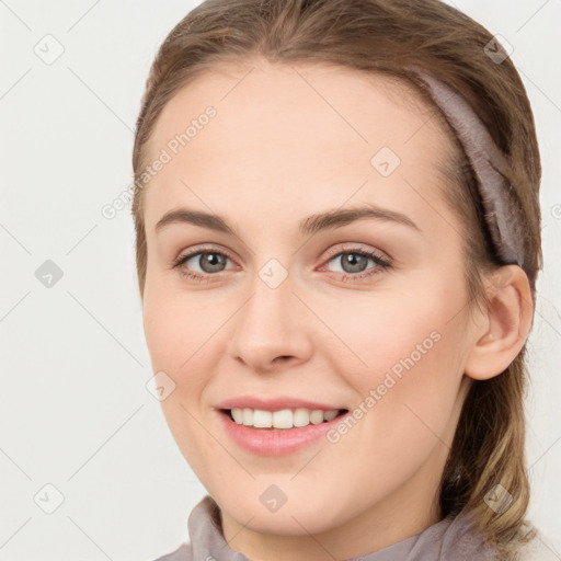 Joyful white young-adult female with medium  brown hair and grey eyes