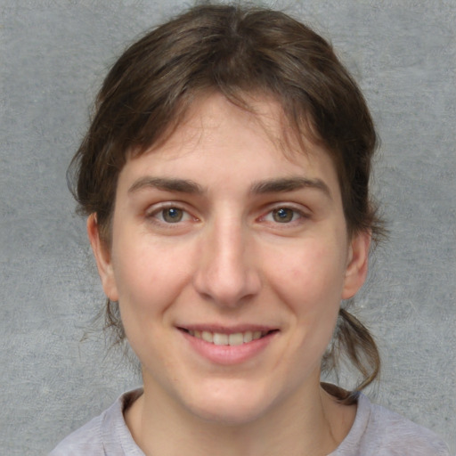 Joyful white young-adult female with medium  brown hair and blue eyes