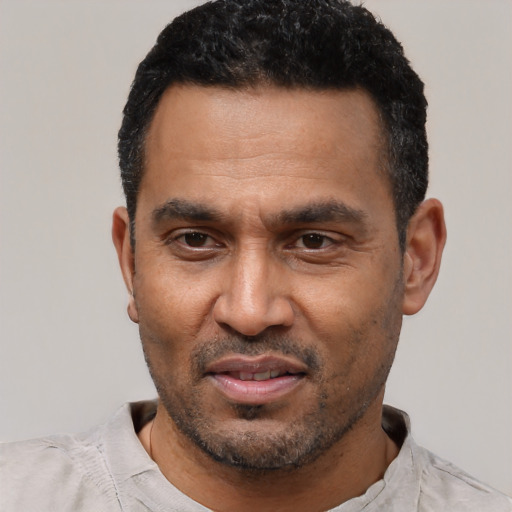 Joyful latino adult male with short  black hair and brown eyes