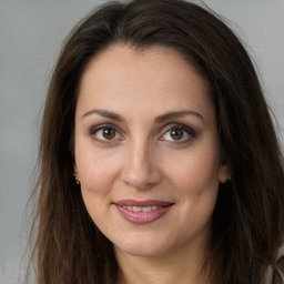 Joyful white adult female with long  brown hair and brown eyes