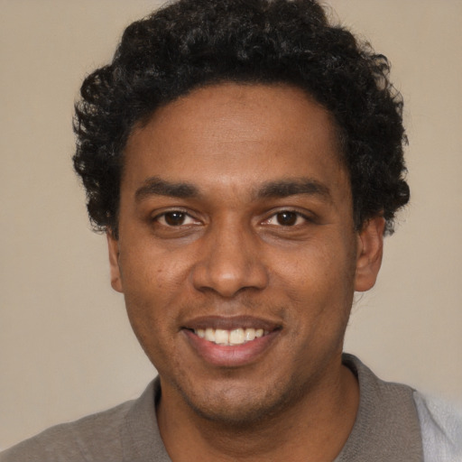 Joyful black young-adult male with short  black hair and brown eyes