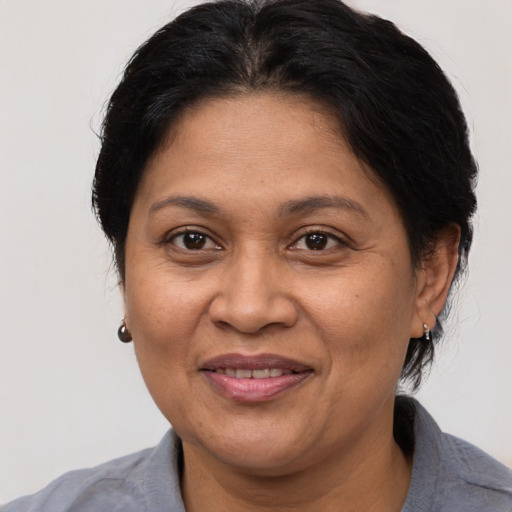 Joyful latino adult female with medium  brown hair and brown eyes