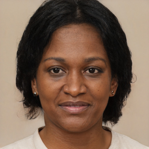 Joyful black adult female with medium  brown hair and brown eyes