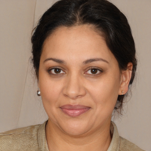 Joyful latino adult female with medium  brown hair and brown eyes