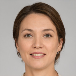 Joyful white young-adult female with medium  brown hair and grey eyes