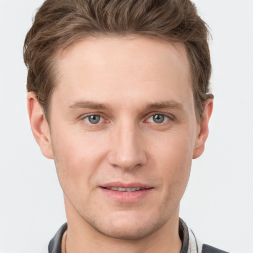 Joyful white young-adult male with short  brown hair and grey eyes