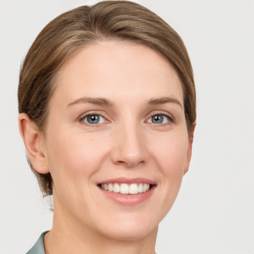 Joyful white young-adult female with short  brown hair and grey eyes